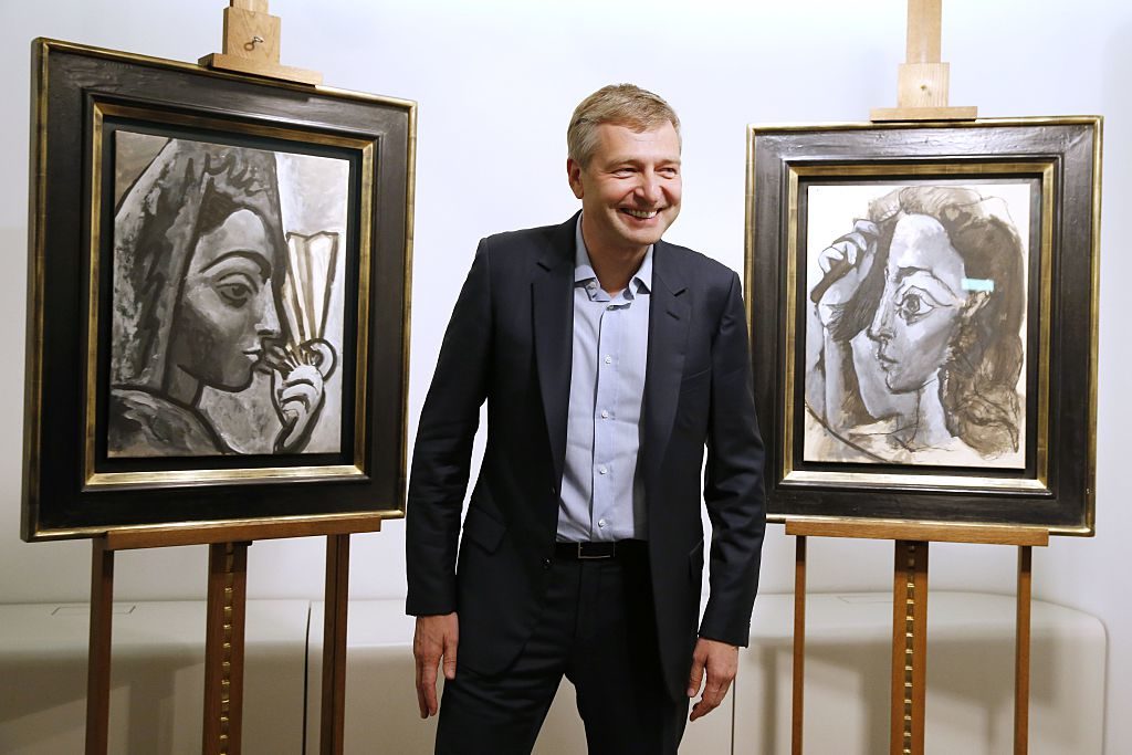 Russian businessperson Dmitry Rybolovlev poses in Paris on September 24, 2015 in front of two allegedly stolen paintings by Pablo Picasso, Espagnole a l'Eventail (left) and Femme se Coiffant, which he purchased from Swiss art dealer Yves Bouvier. Image courtesy AFP Photo/Patrick Kovarik.