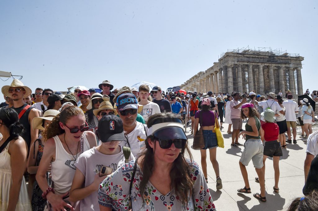 Atop the Acropolis ancient hill, tourists visit the Parthenon temple during a heat wave on July 20, 2023 in Athens, Greece. The Acropolis of Athens and other archaeological sites in Greece announced reduced opening hours due to the heatwave conditions. Photo by Milos Bicanski/Getty Images.