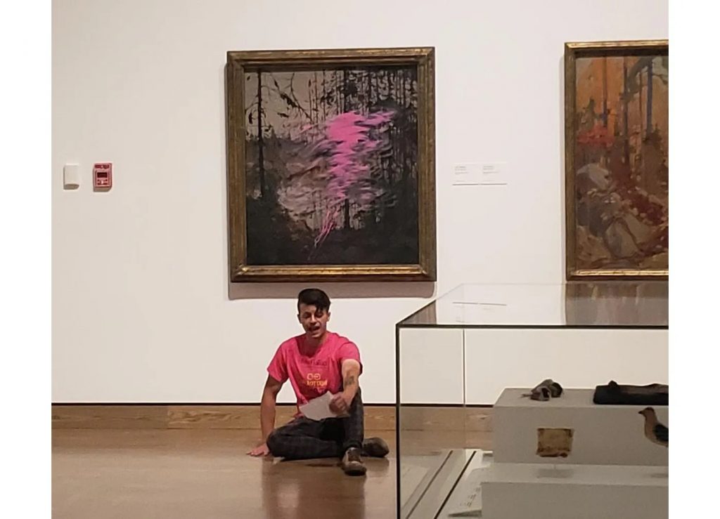 On2Ottawa climate activist Kaleb Suedfeld threw paint on a work at the National Gallery of Canada in Ottawa and then glued his hand to the floor. Police arrested him following the protest. Photo courtesy of On2Ottawa.